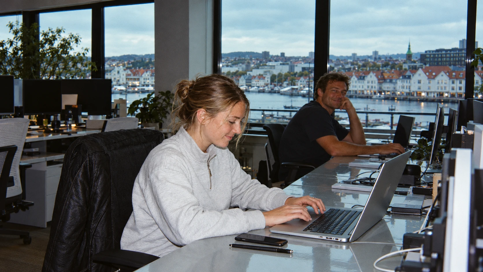 Candidates working at laptops in an office over the harbour